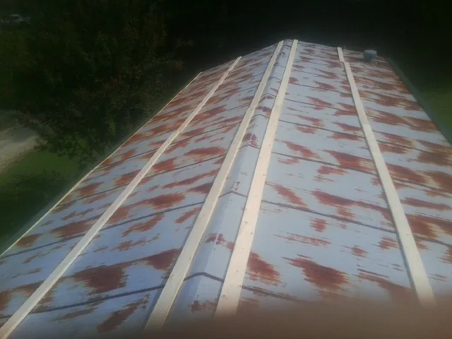 Rusted metal roof panels with new wood purlins before replacement — Storm Damage Roof Repair in Mount Solon by Roofing Brothers